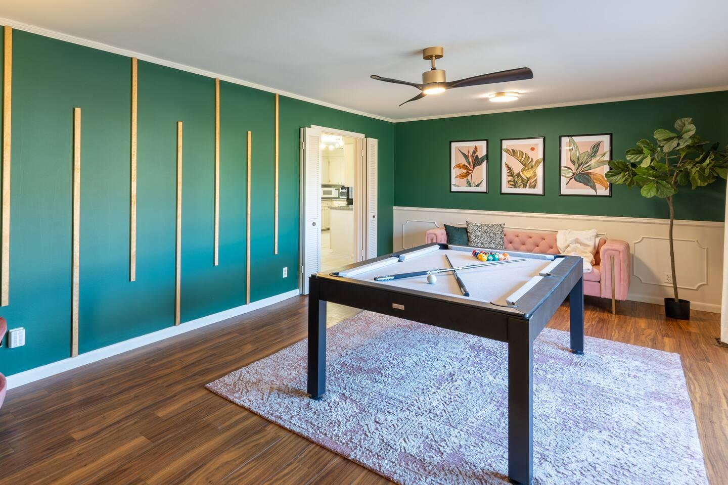Front living room - Beautiful pool table with a cute barrel chair and a long blush sofa .